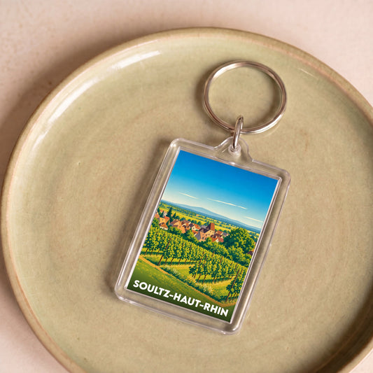 Porte-clés souvenir de la ville de Soultz-Haut-Rhin avec une illustration stylisée de vignobles.