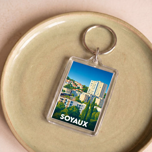 Porte-clés souvenir de la ville de Soyaux avec une illustration urbaine colorée.