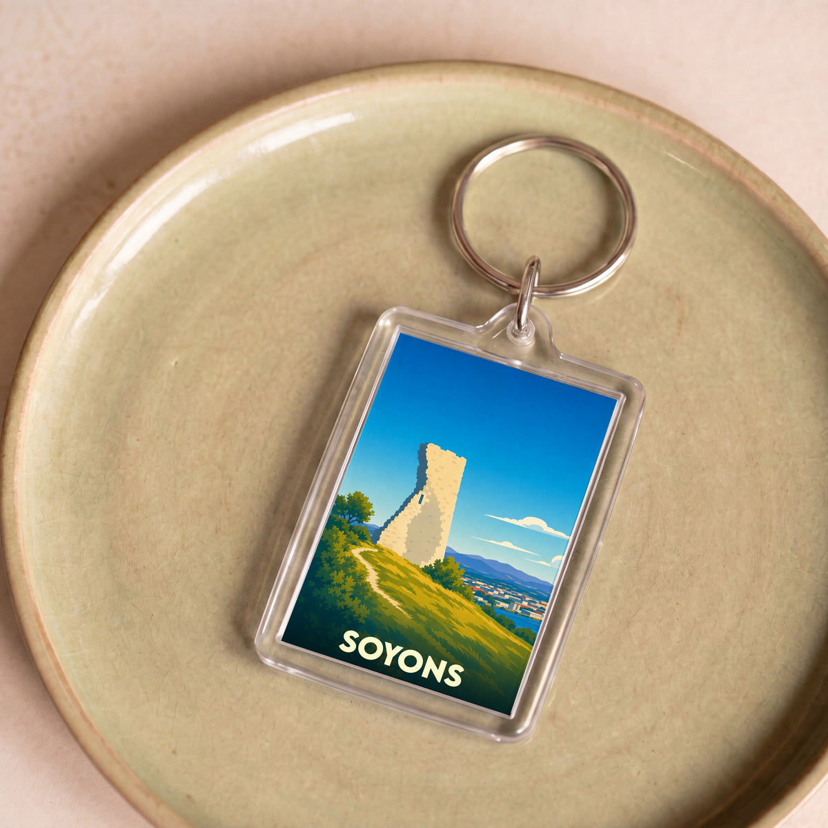 Porte-clés souvenir de la ville de Soyons illustrant sa tour médiévale dans un style épuré.