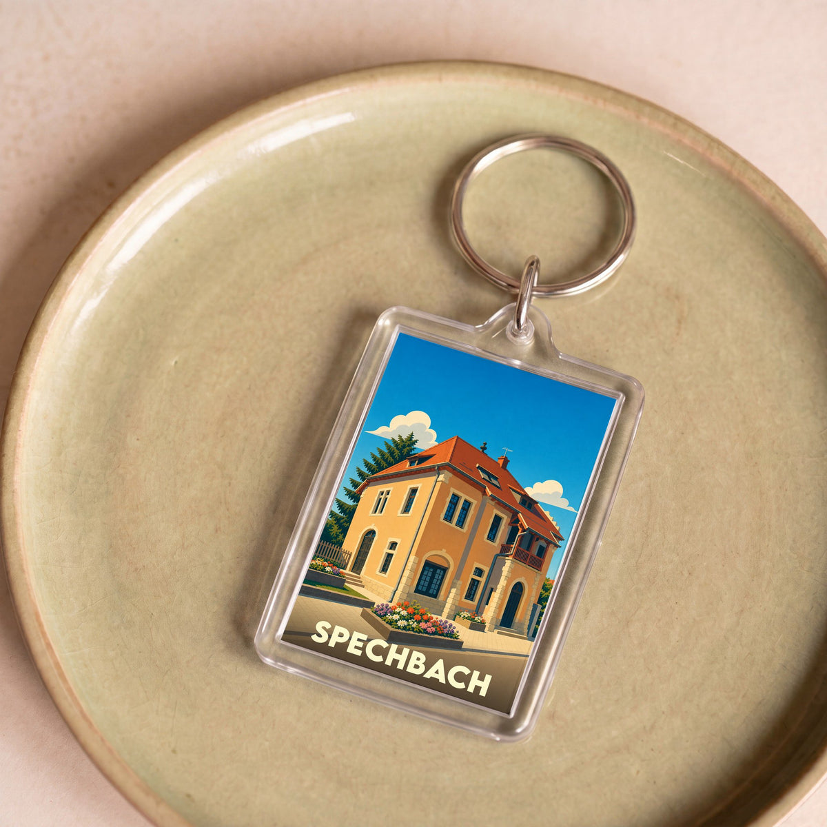 Porte-clés souvenir de la ville de Spechbach avec une illustration stylisée d'une maison traditionnelle.