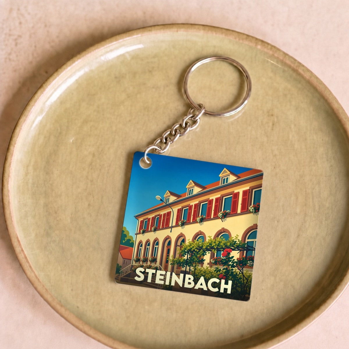 Porte-clés souvenir de la ville de Steinbach avec une illustration stylisée.