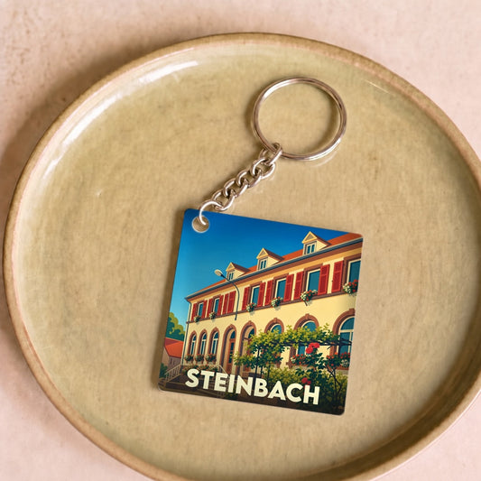Porte-clés souvenir de la ville de Steinbach avec une illustration stylisée.