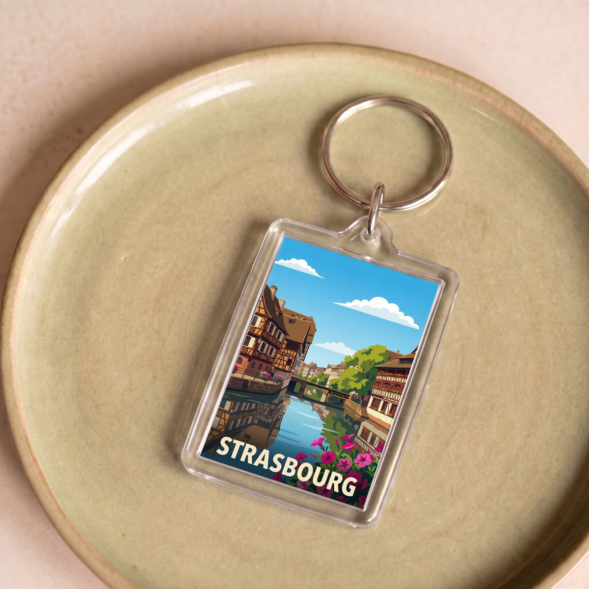 Porte-clés souvenir de la ville de Strasbourg avec une illustration stylisée de ses maisons à colombages.