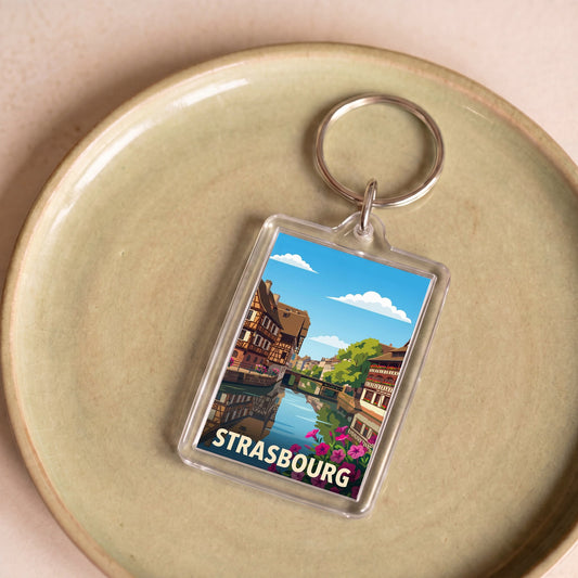 Porte-clés souvenir de la ville de Strasbourg avec une illustration stylisée de ses maisons à colombages.