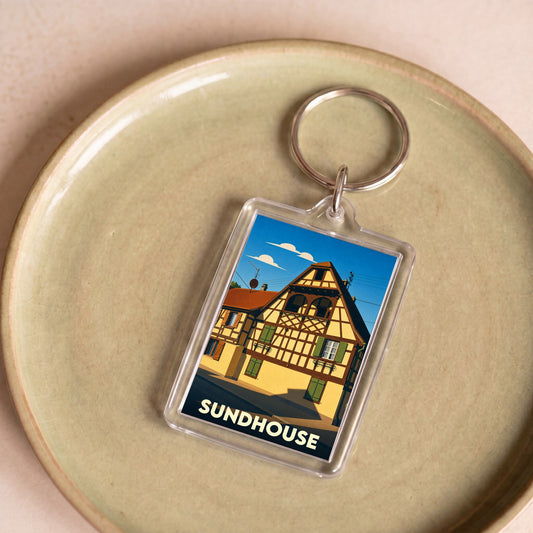 Porte-clés souvenir de la ville de Sundhouse avec une illustration stylisée d'une maison à colombages.