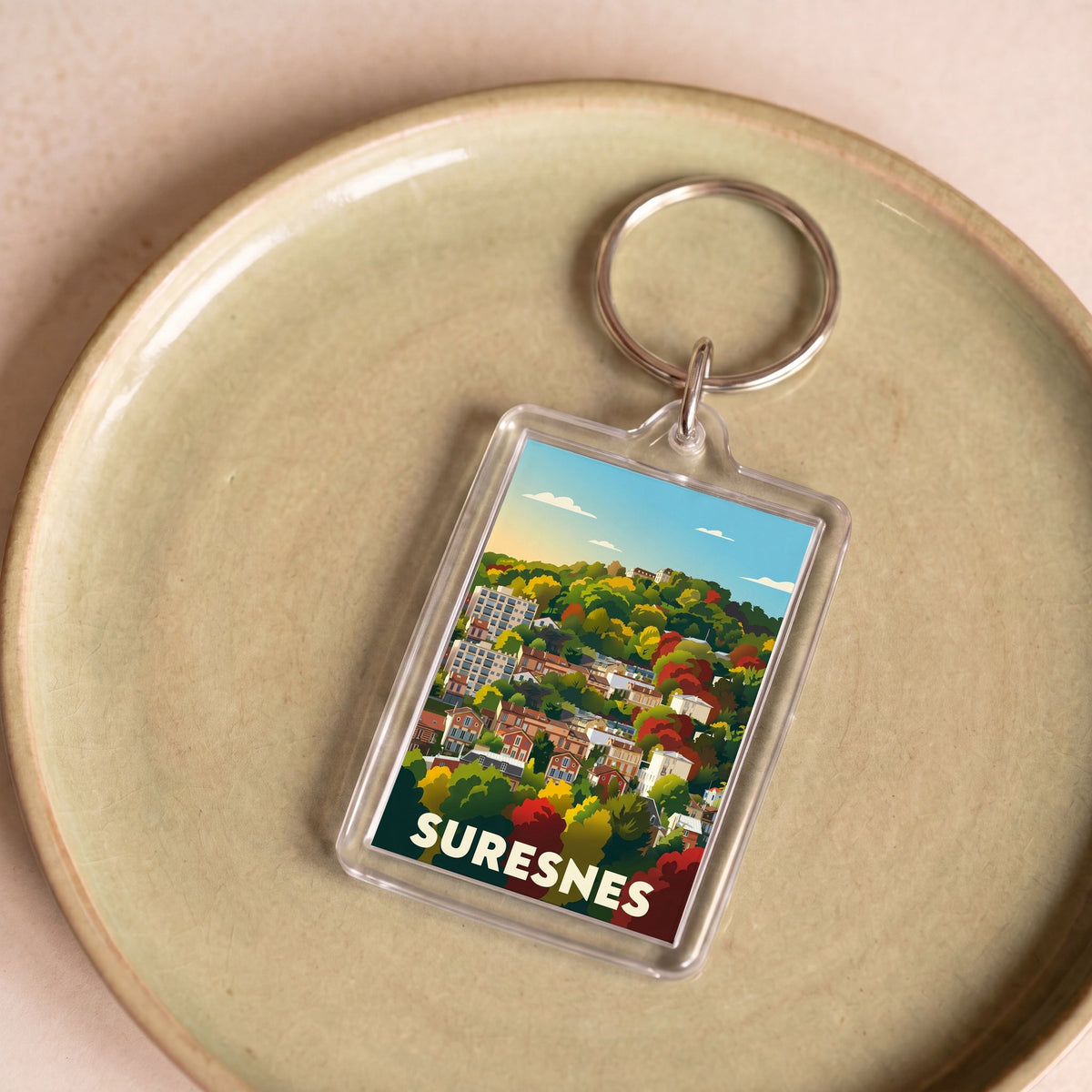 Porte-clés souvenir de la ville de Suresnes arborant une illustration stylisée et colorée.