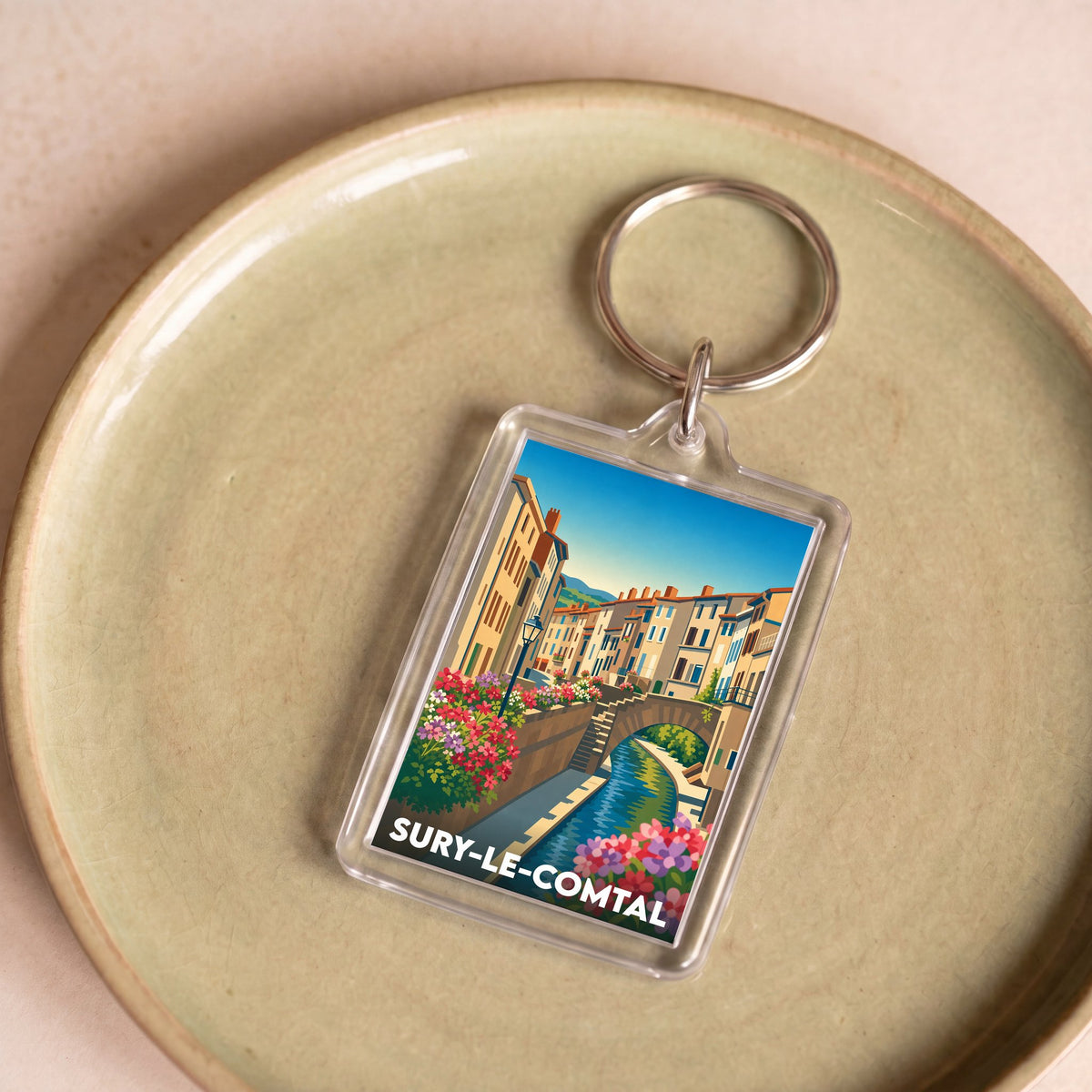 Porte-clés souvenir de la ville de Sury-le-Comtal avec une illustration stylisée.