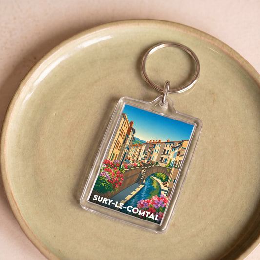 Porte-clés souvenir de la ville de Sury-le-Comtal avec une illustration stylisée.