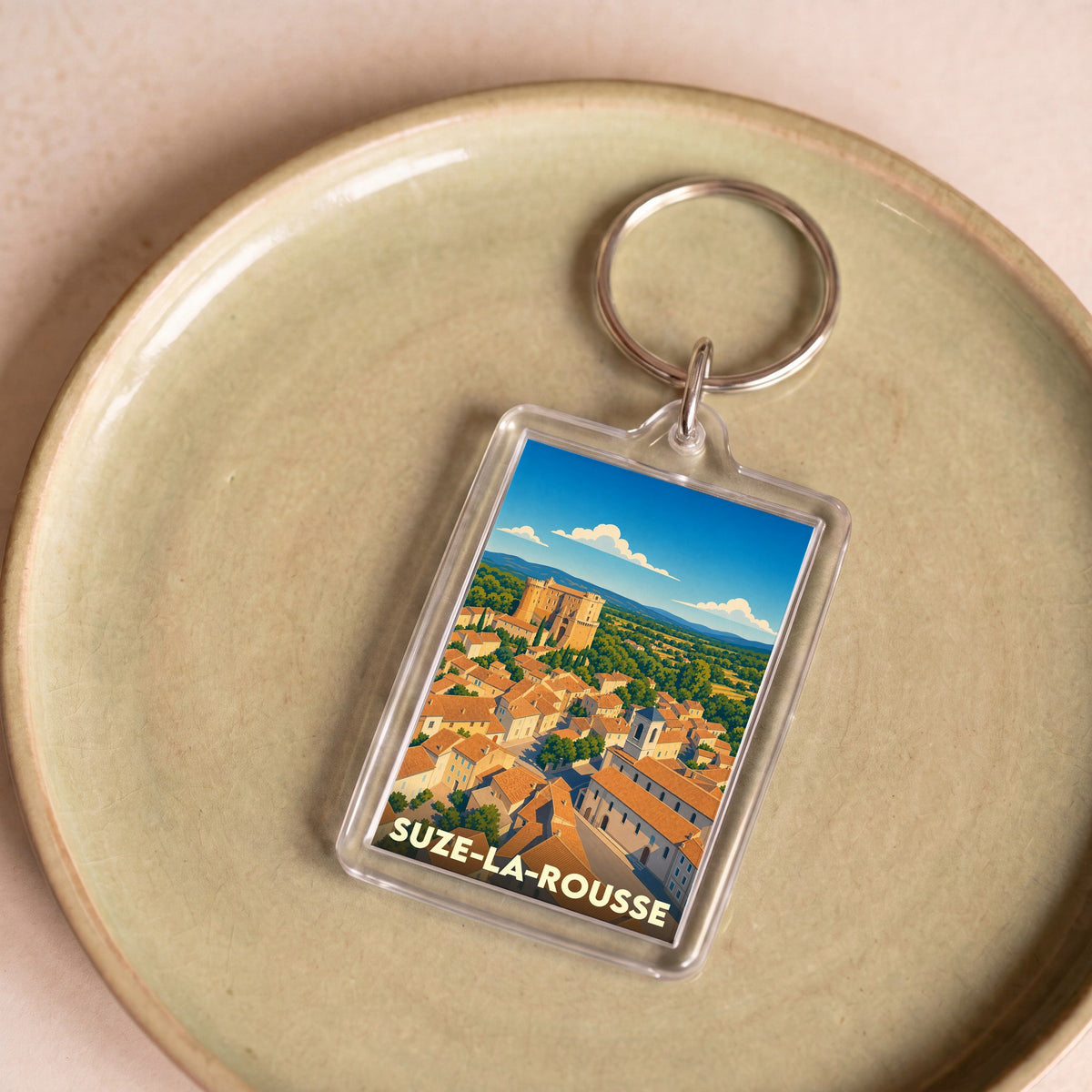 Porte-clés souvenir de la ville de Suze-la-Rousse avec une illustration stylisée.