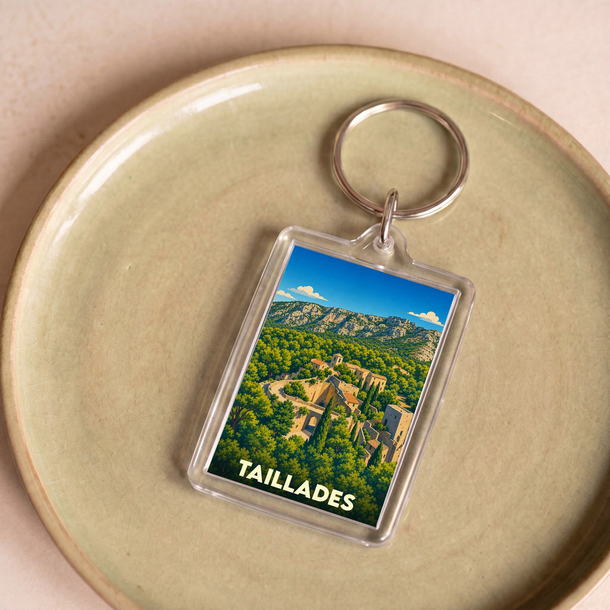 Porte-clés souvenir de la ville de Taillades avec une illustration stylisée de son vieux village.