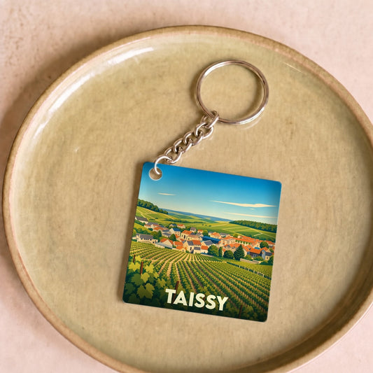 Porte-clés souvenir de la ville de Taissy avec une illustration stylisée de vignobles.