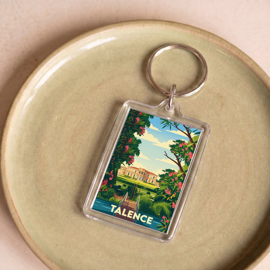 Porte-clés souvenir de la ville de Talence avec une illustration stylisée d'un paysage verdoyant.