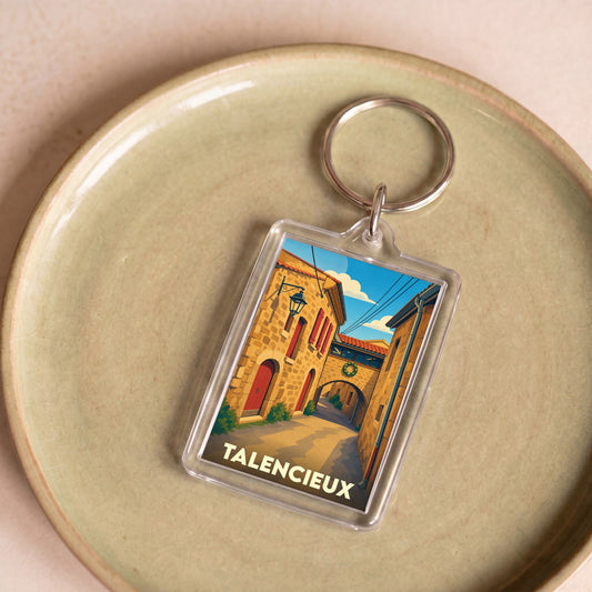 Porte-clés souvenir de la ville de Talencieux avec une illustration stylisée d'une ruelle ensoleillée.