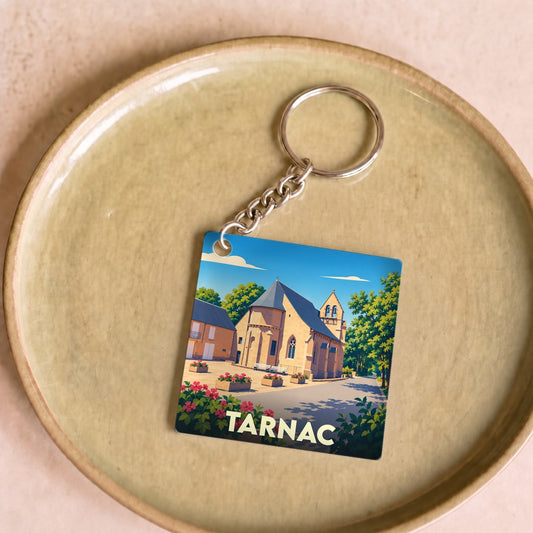 Porte-clés souvenir de la ville de Tarnac avec une illustration stylisée de son église.