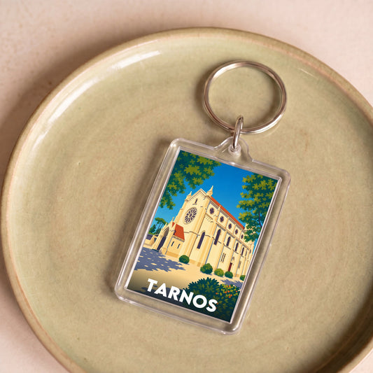 Porte-clés souvenir de la ville de Tarnos avec une illustration stylisée d'une église.