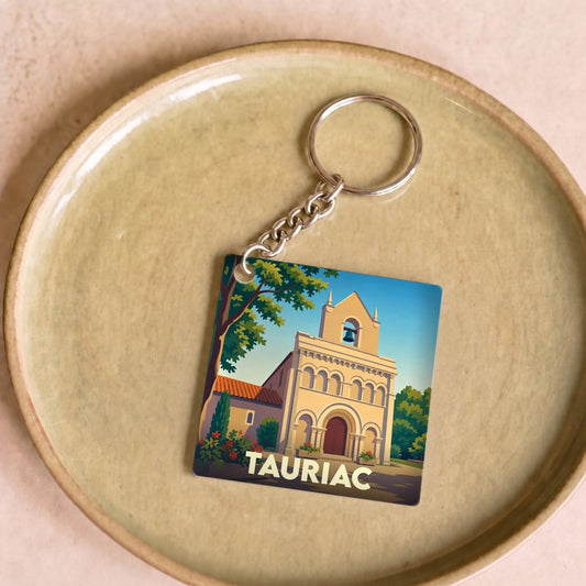 Porte-clés souvenir de la ville de Tauriac avec une illustration stylisée de son église.