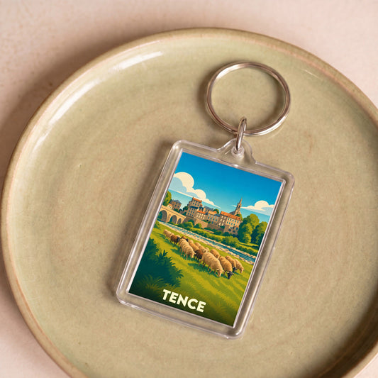 Porte-clés souvenir de la ville de Tence avec une illustration stylisée d'un paysage pastoral.