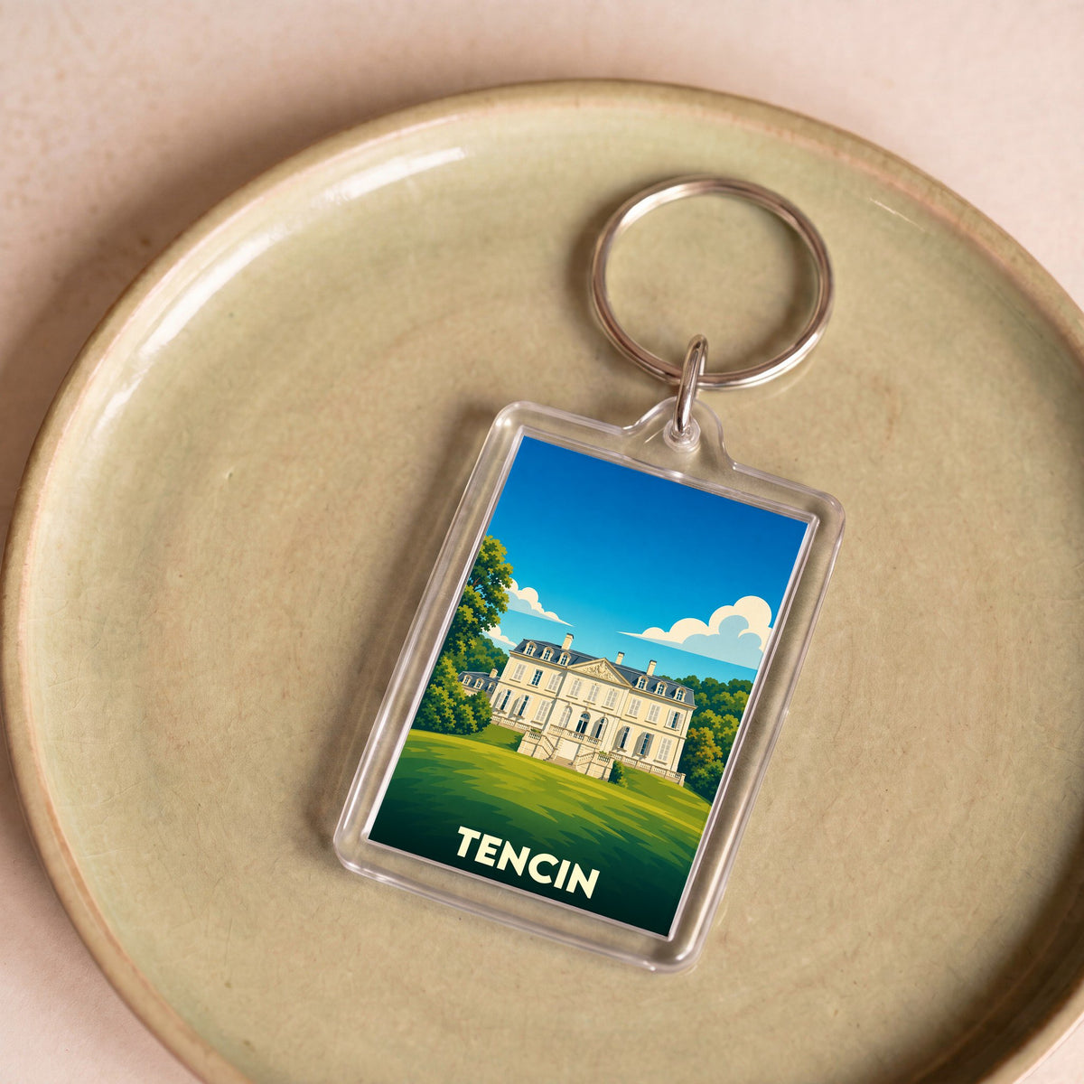 Porte-clés souvenir de la ville de Tencin avec une illustration stylisée de son château.