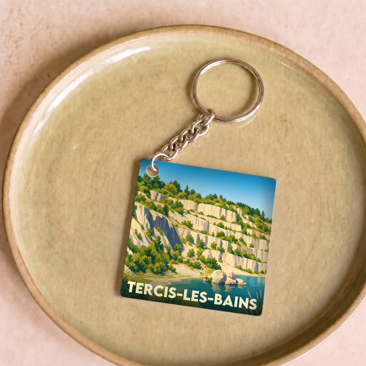 Porte-clés souvenir de la ville de Tercis-les-Bains avec une illustration stylisée d'une ancienne carrière et de son lac.