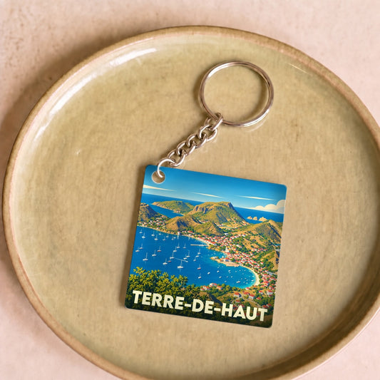 Porte-clés souvenir de Terre-de-Haut arborant une illustration stylisée de sa baie et de ses collines.