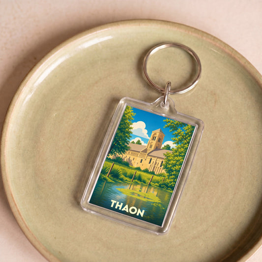 Porte-clés souvenir de la ville de Thaon avec une illustration stylisée de son église au bord de l'eau.