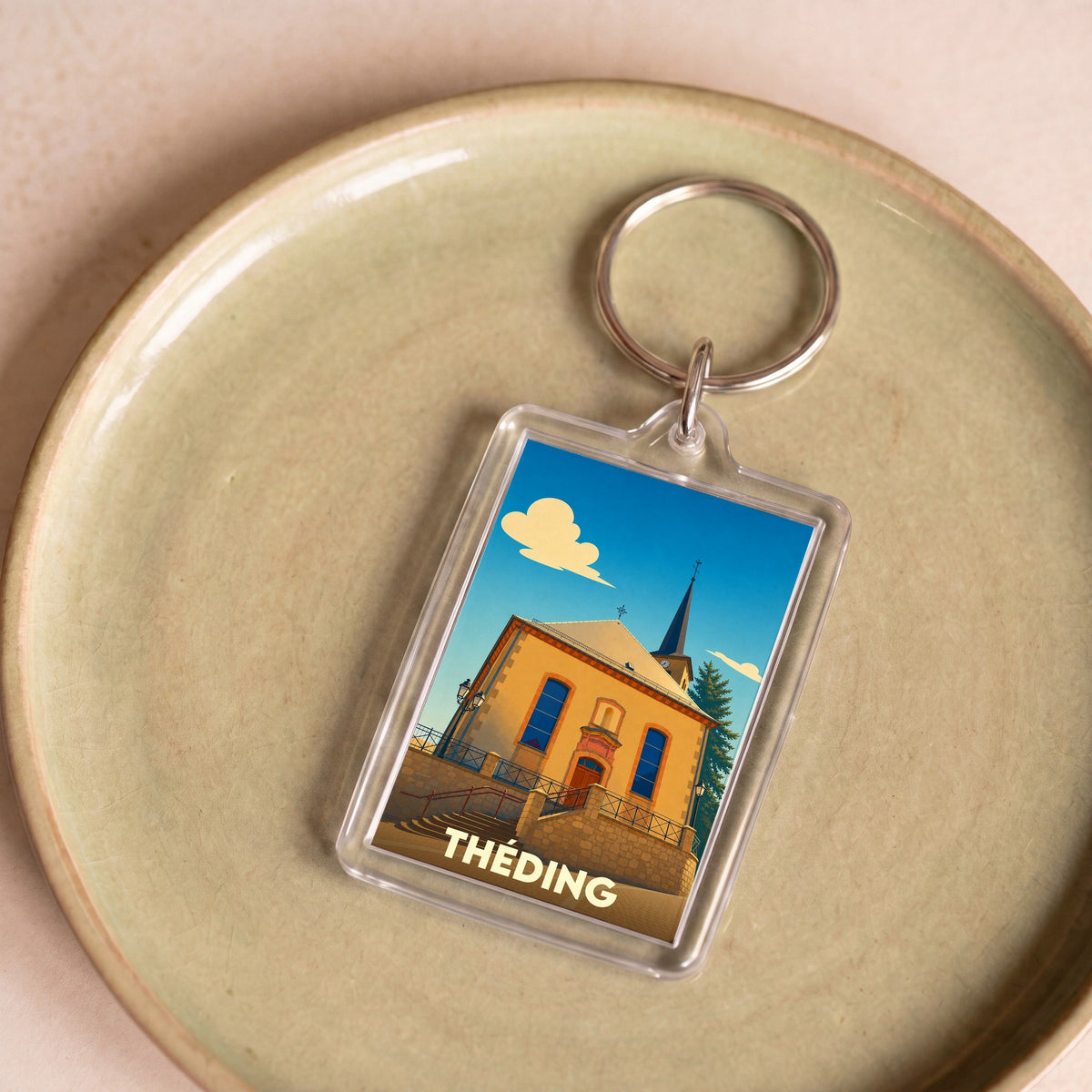 Porte-clés souvenir de la ville de Théding avec une illustration stylisée de son église.