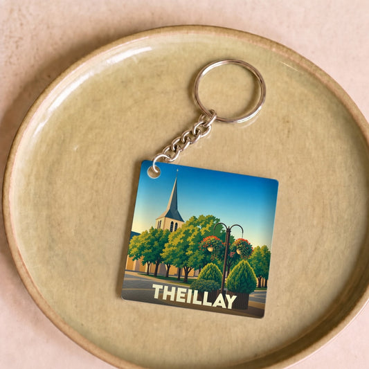 Porte-clés souvenir de la ville de Theillay avec une illustration stylisée d'un clocher et de jardins.