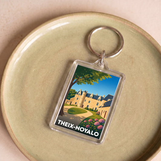 Porte-clés souvenir de la ville de Theix-Noyalo avec une illustration stylisée d'un château.