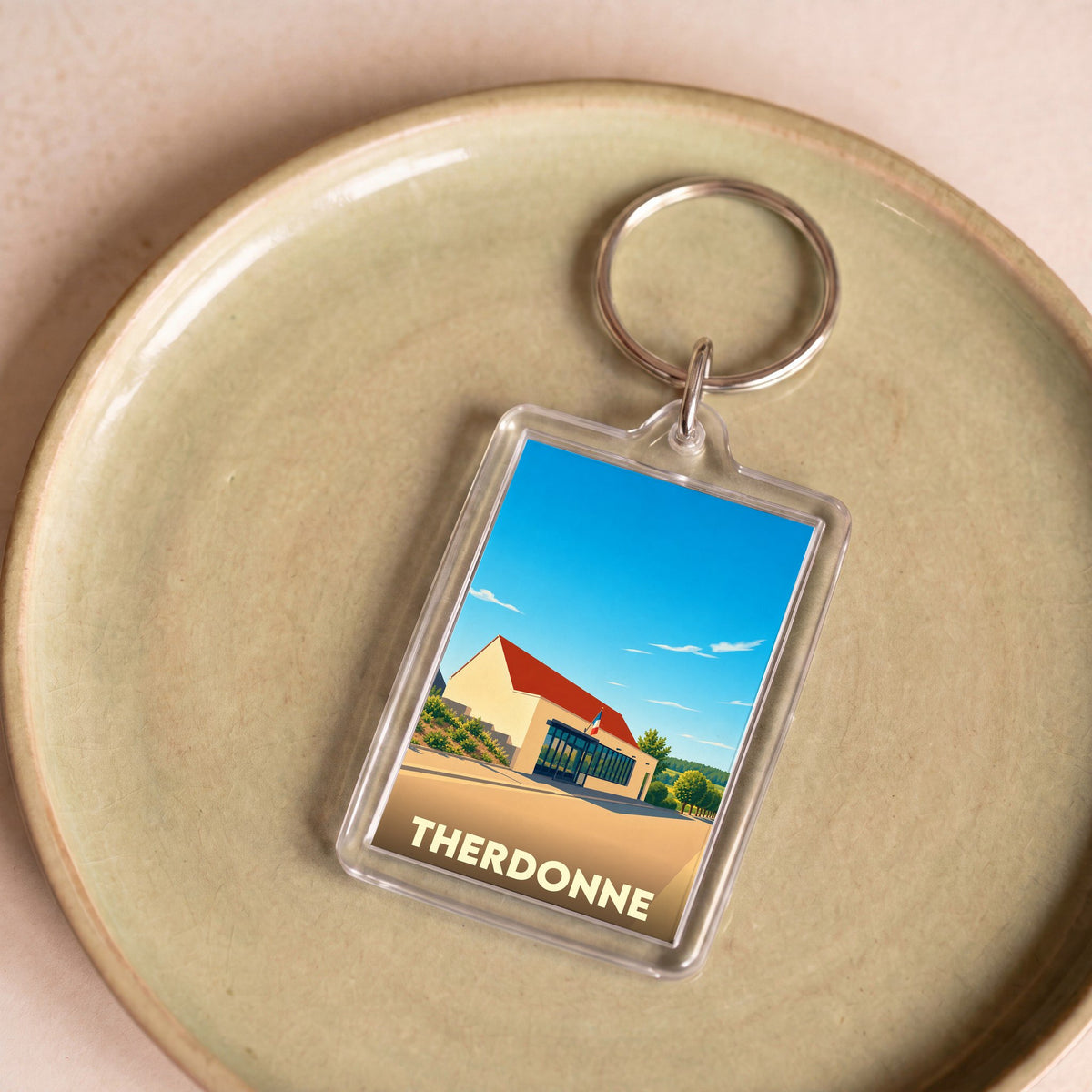 Porte-clés souvenir de la ville de Therdonne avec une illustration stylisée.