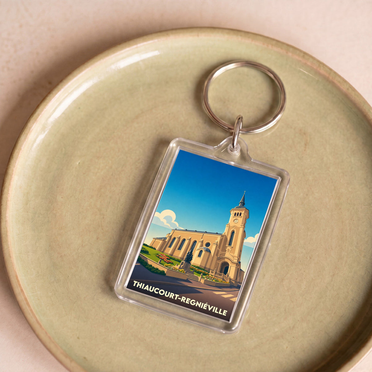 Porte-clés souvenir de la ville de Thiaucourt-Regniéville avec une illustration stylisée de son église.