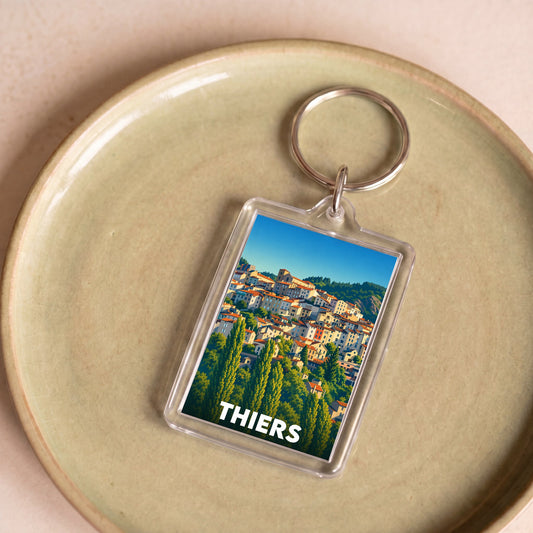 Porte-clés souvenir de la ville de Thiers avec une illustration stylisée de ses maisons à flanc de colline.