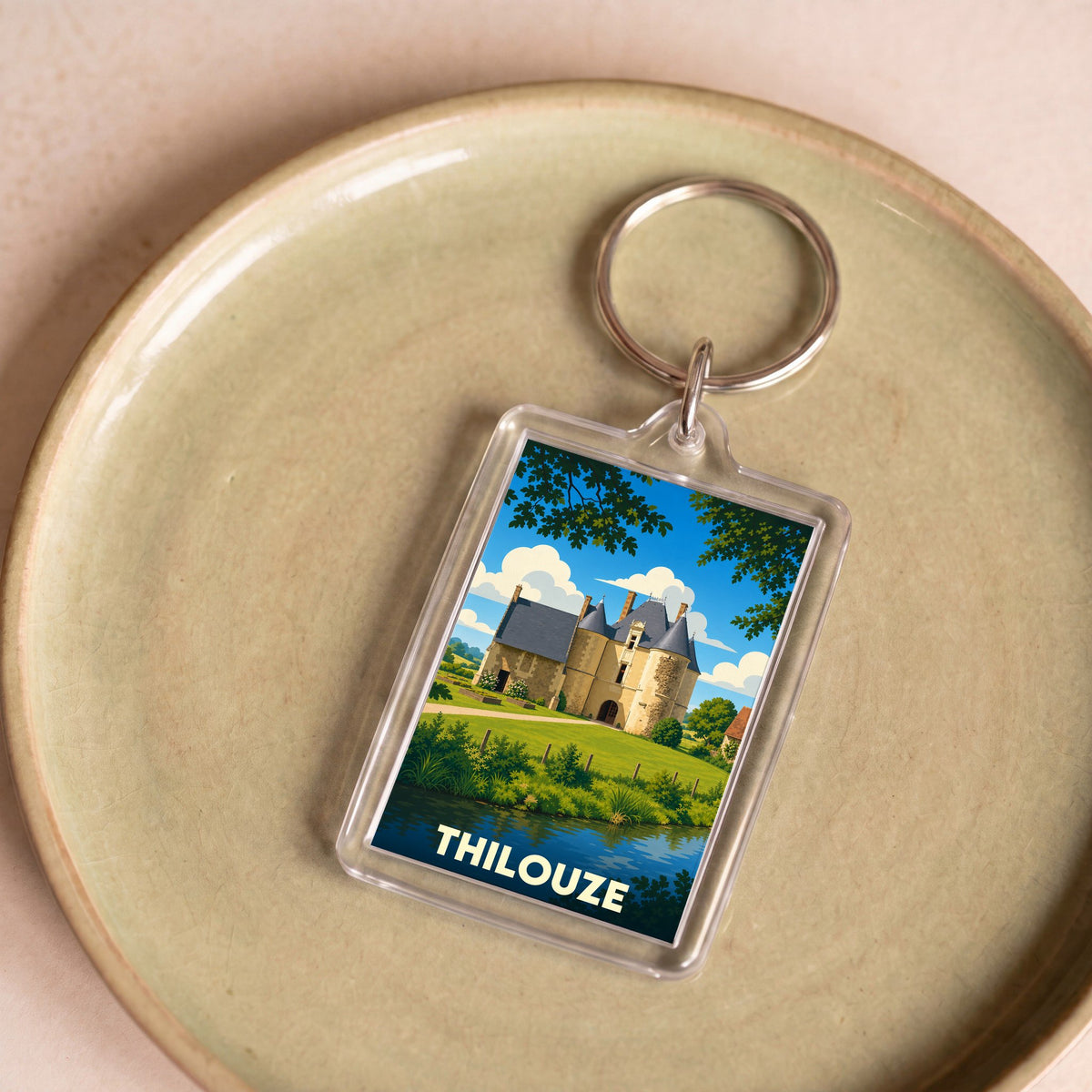 Porte-clés souvenir de la ville de Thilouze avec une illustration stylisée d'un château.