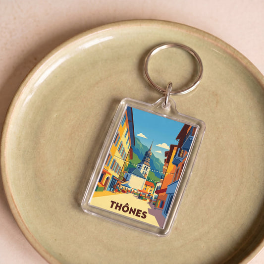 Porte-clés souvenir de la ville de Thônes avec une illustration stylisée.