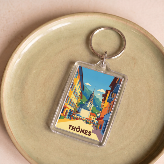 Porte-clés souvenir de la ville de Thônes avec une illustration stylisée.