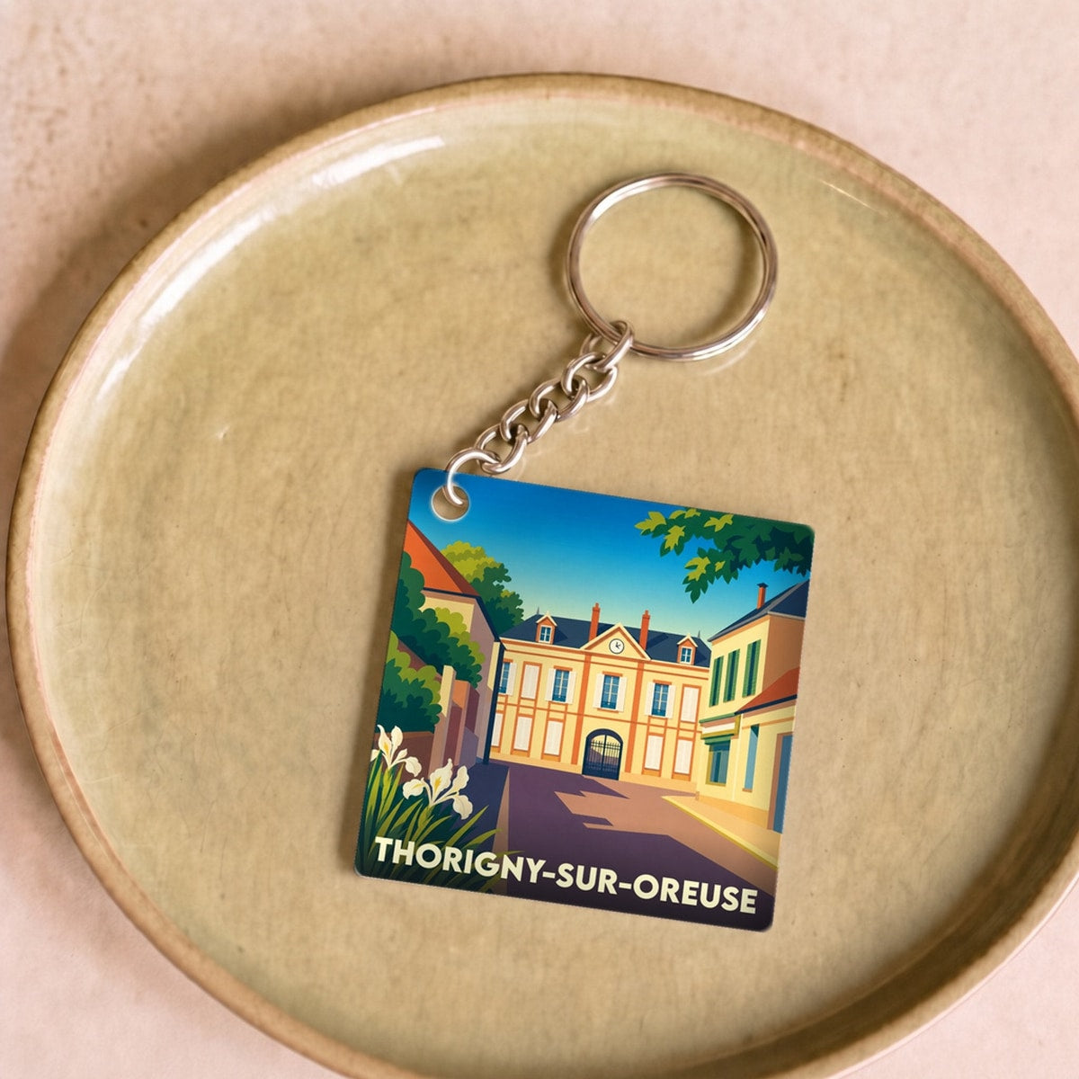 Porte-clés souvenir de la ville de Thorigny-sur-Oreuse avec une illustration stylisée.