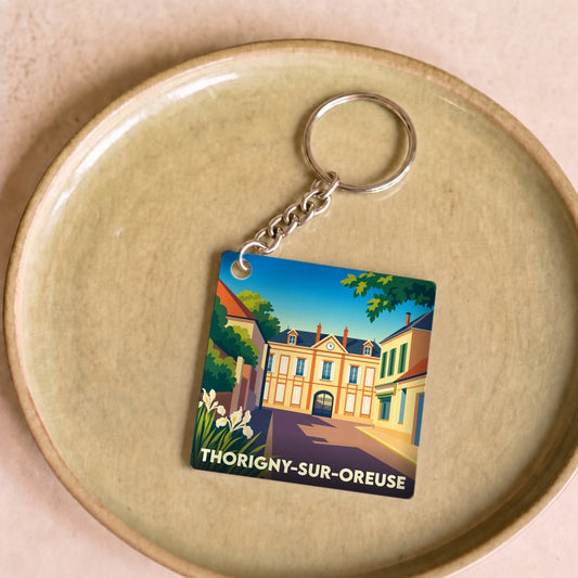 Porte-clés souvenir de la ville de Thorigny-sur-Oreuse avec une illustration stylisée.