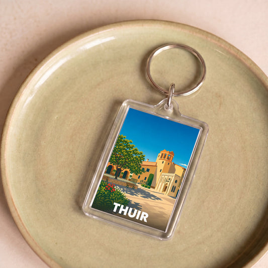 Porte-clés souvenir de la ville de Thuir avec une illustration stylisée.