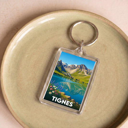 Porte-clés souvenir de la ville de Tignes avec une illustration stylisée de paysage de montagne.