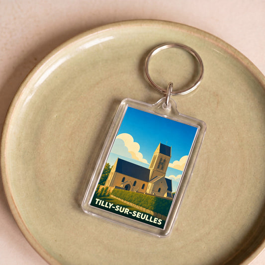 Porte-clés souvenir de la ville de Tilly-sur-Seulles avec une illustration stylisée de son église.