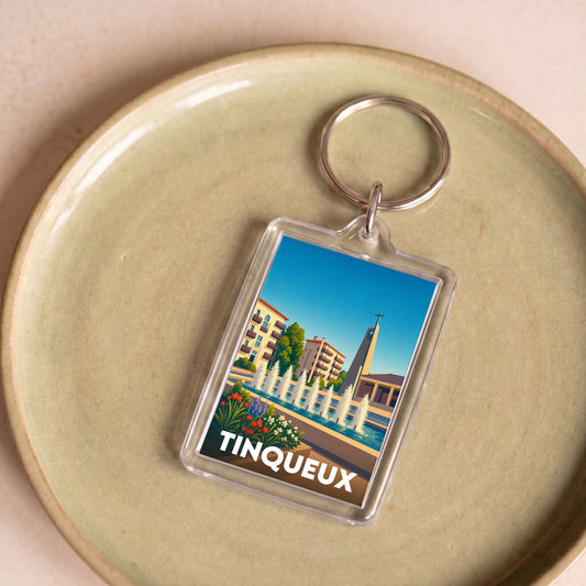Porte-clés souvenir de la ville de Tinqueux avec une illustration stylisée.