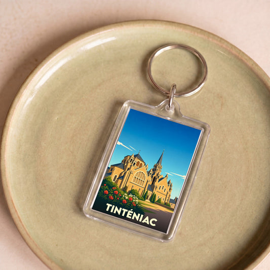 Porte-clés souvenir de la ville de Tinténiac avec une illustration stylisée de son église.