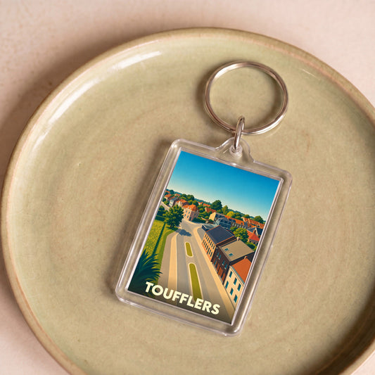 Porte-clés souvenir de la ville de Toufflers avec une illustration stylisée.