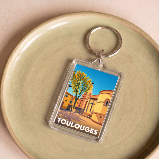 Porte-clés souvenir de la ville de Toulouges avec une illustration stylisée.