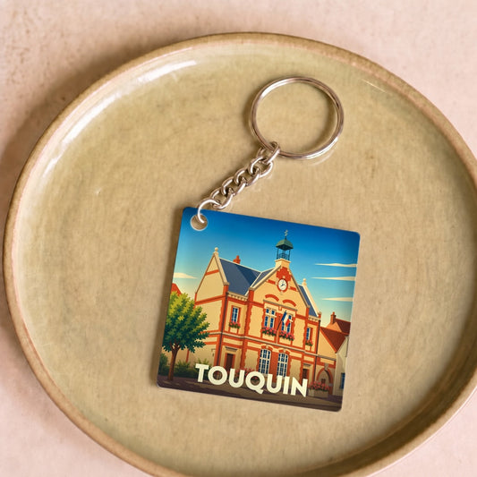 Porte-clés souvenir de la ville de Touquin avec une illustration stylisée de sa mairie.