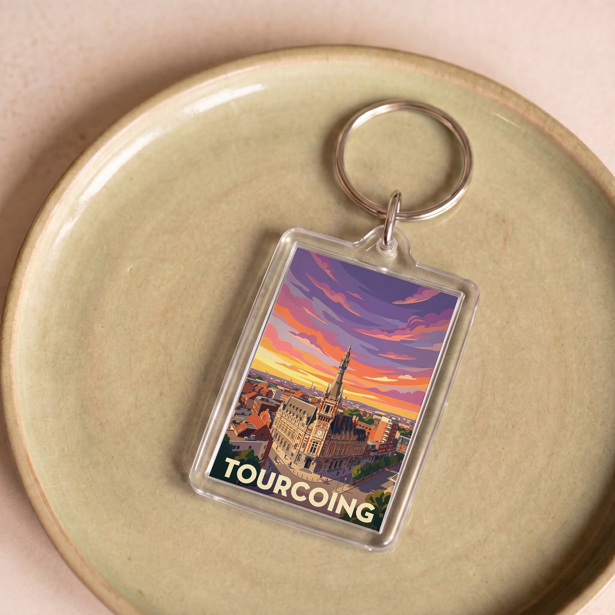 Porte-clés souvenir de la ville de Tourcoing avec une illustration stylisée du paysage urbain.