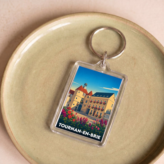 Porte-clés souvenir de la ville de Tournan-en-Brie avec une illustration stylisée.