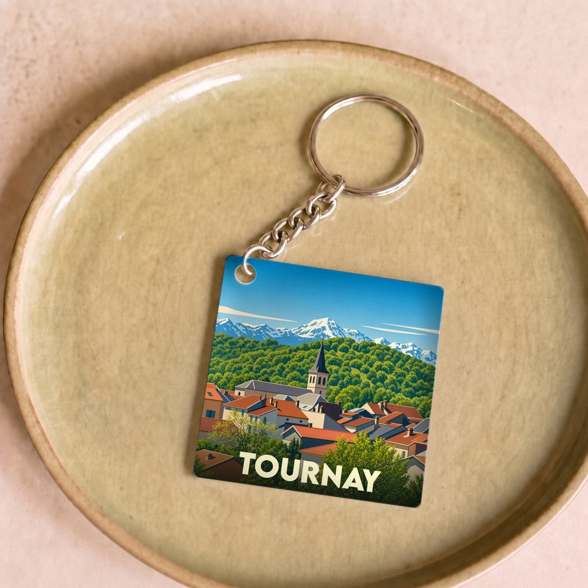 Porte-clés souvenir de la ville de Tournay avec une illustration stylisée.