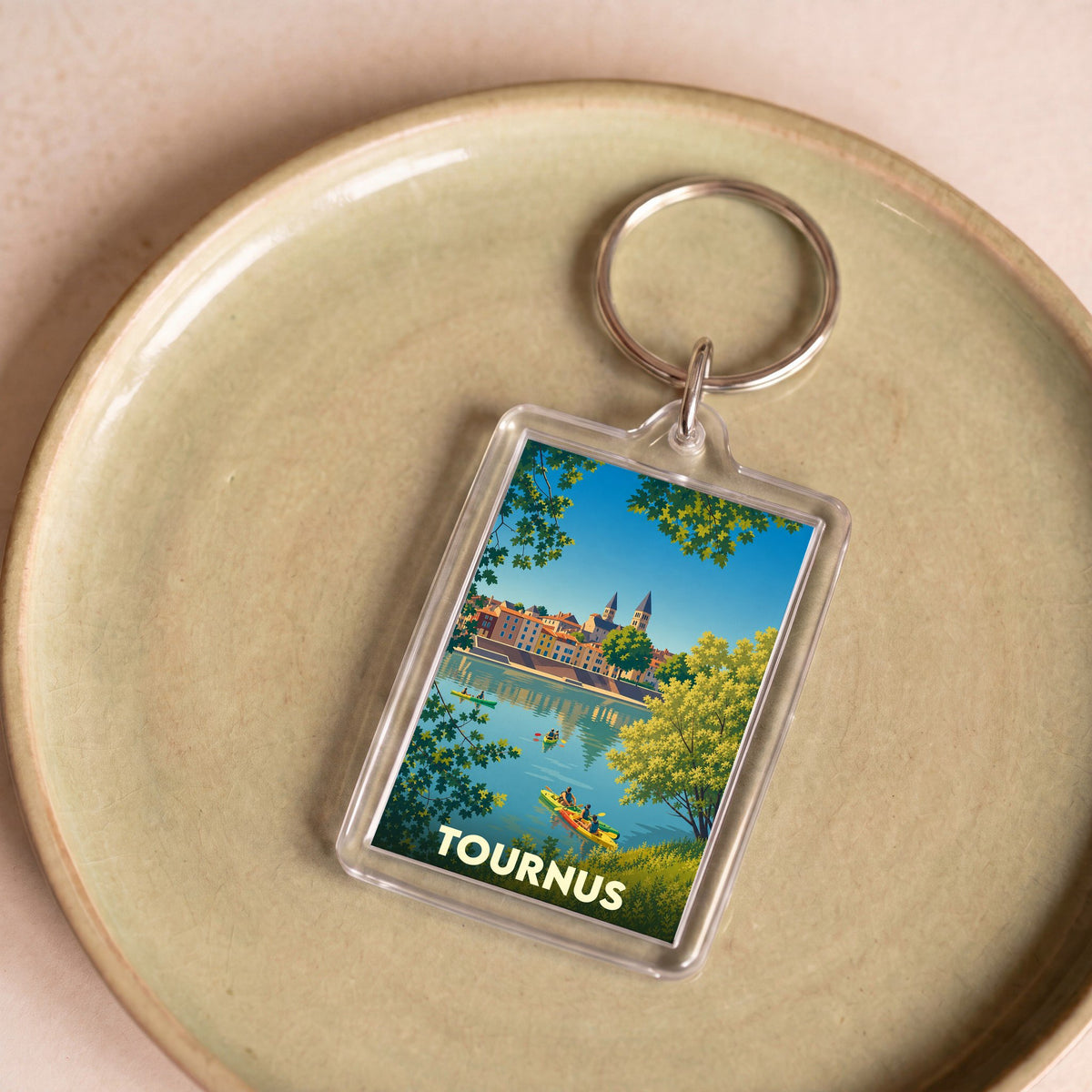 Porte-clés souvenir de la ville de Tournus avec une illustration stylisée d'une scène de canoë sur la Saône.