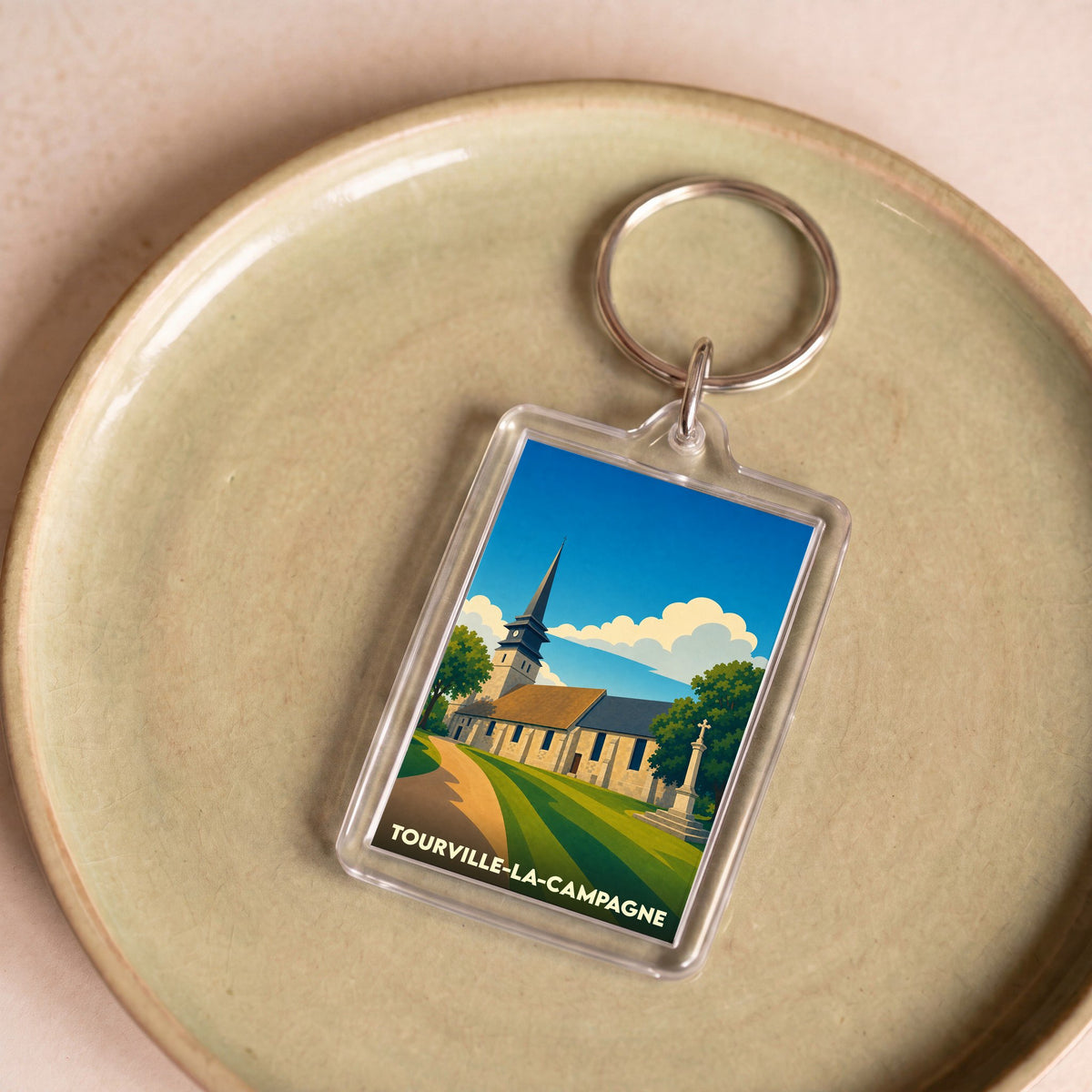 Porte-clés souvenir de la ville de Tourville-la-Campagne avec une illustration stylisée de son église.