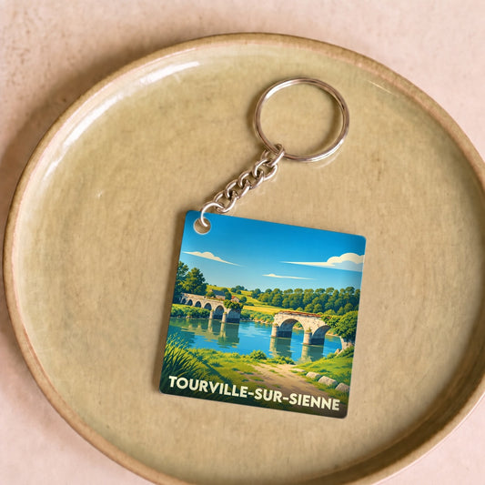Porte-clés souvenir de la ville de Tourville-sur-Sienne avec une illustration stylisée d'un pont en pierre.